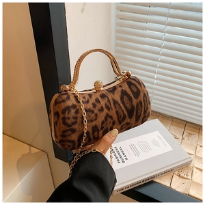 Détail de pochette de soirée léopard avec finitions dorées et fermoir en cristal
