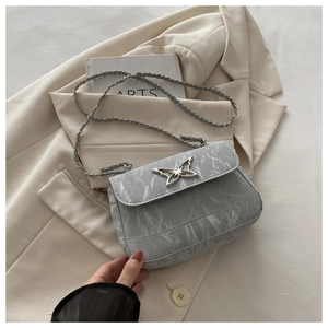 Detail of light grey marble pattern crossbody bag with silver butterfly metal clasp