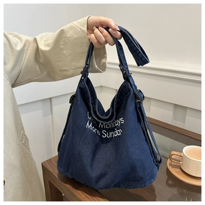 Détail du sac cabas en jean bleu avec broderie blanche et boucle de sangle réglable