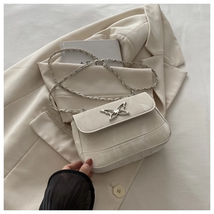 Detailed view of cream crossbody bag with silver butterfly clasp and marble texture