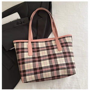 Macro detail of pink plaid canvas tote bag with textured straps and elegant piping
