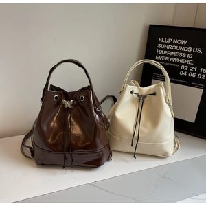 Detail of vintage bucket bags with butterfly metal drawstring locks in brown and cream