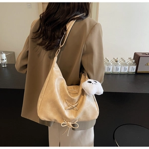 Detail of beige large capacity tote bag featuring lace-up drawstring and ghost pendant