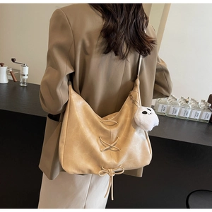 Detail of beige large capacity faux leather tote bag with lace-up design and ghost charm