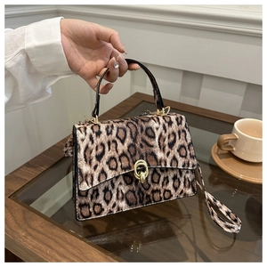 Detail of leopard print handbag with golden interlocking buckle and textured faux fur finish