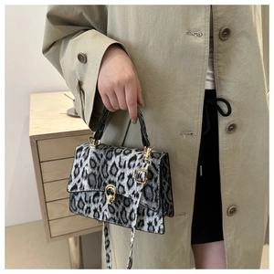 Detailed shot of leopard print faux fur crossbody bag with round metal buckle lock