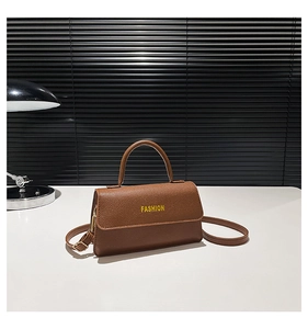 Close-up of brown litchi pattern handbag with a fashion letter logo and top handle