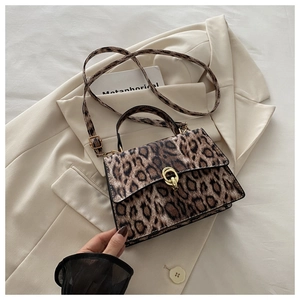 Close-up of leopard print crossbody bag featuring a golden metal twist lock and top handle