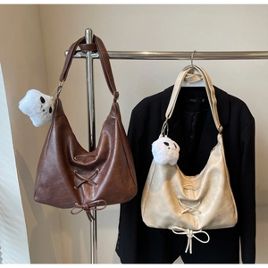 Detail of retro vintage shoulder bags with lace-up bows and plush ghost charms