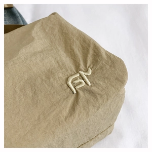Macro shot of khaki nylon fabric texture and detailed white line embroidery logo