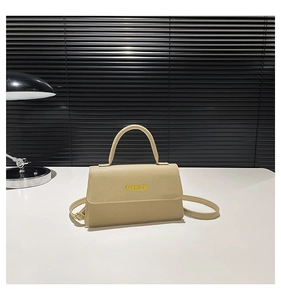 Close-up of beige lychee textured leather small square bag with yellow FASHION text