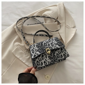 Close-up of leopard print crossbody bag with gold buckle and adjustable strap