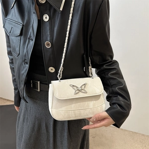 Chic cream crossbody flap bag with butterfly buckle and chain strap on female model