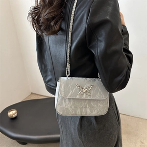 Silver crinkled metallic crossbody bag with butterfly metal piece and chain strap