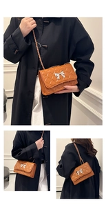 Close-up of quilted brown handbag with silver bow detail and metal chain strap