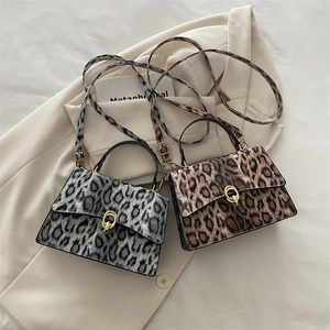 Leopard print crossbody bags with golden ring clasp on a beige blazer background