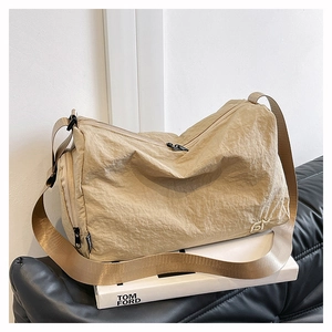 Detail of beige nylon boston bag with pleated texture and adjustable wide strap