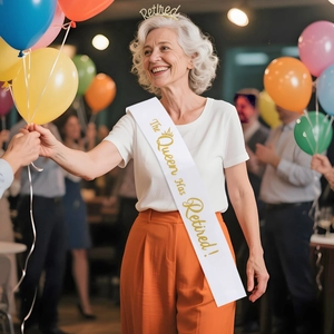 White satin sash and rhinestone tiara set worn by a woman at a retirement party