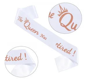 Close-up of white satin sash with rose gold glitter The Queen Has Retired lettering