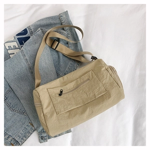 Detailed top view of beige nylon cylinder crossbody bag with textured fabric and zipper
