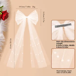 Detail of bridal pearl bow hair clip with white mesh ribbon and metal spring clip back