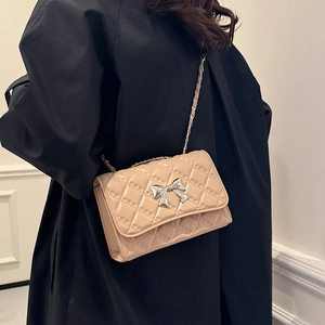 Quilted beige crossbody bag with silver bow buckle and elegant metal chain strap