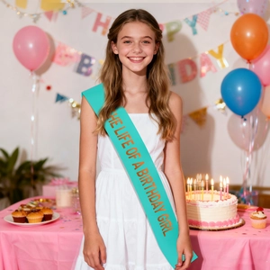Blue satin birthday girl sash with gold lettering worn at a colorful celebration party