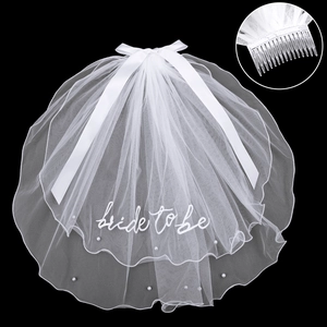 Two-tier white bridal veil with pearls, bow, and 'bride to be' embroidery on black background