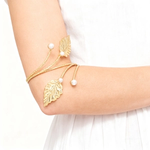 Goddess style gold leaf arm cuff with pearls on female model in bright natural light