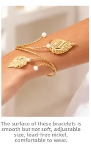 Detailed view of golden leaf arm cuff featuring white pearls and adjustable spiral design