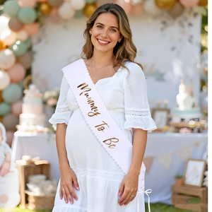 Close-up of Mummy To Be white satin sash with gold foil lettering and wavy edges