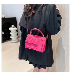 Detail of pink embossed tote bag with braided handle and matching mini purse attachment