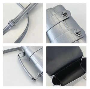 Detail view of silver crossbody bag featuring dual metal buckles and textured faux leather