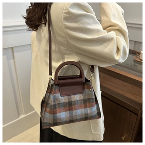 Détail du sac à main en laine à carreaux vintage avec poignée marron et texture britannique