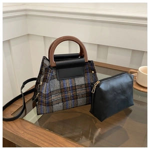 Détail de l'ensemble sac à main en laine à carreaux avec poignées rondes brunes dans un café