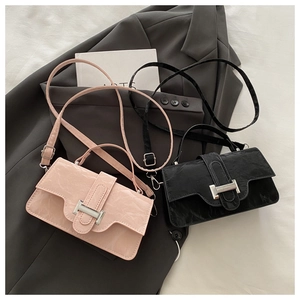 Detail showing two wrinkled leather crossbody bags in pink and black with silver buckles