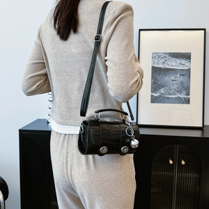 Black crocodile pattern cylinder bag with silver dual locks and adjustable strap