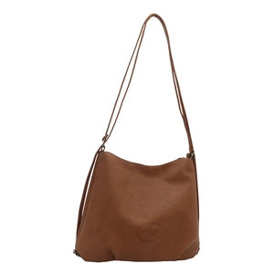 Brown leather crossbody tote bag with minimalist logo patch and adjustable strap