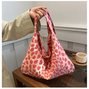 Détail de la texture du sac cabas imprimé léopard en tissu rose et beige