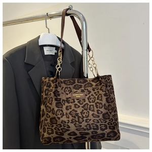 Détail du sac cabas léopard avec bandoulière chaîne dorée et étiquette de mode