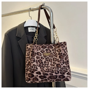 Détail du sac cabas léopard avec anses marron et accent de chaîne en métal stylé