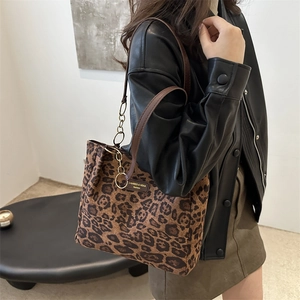 Grand sac cabas léopard avec bandoulière en cuir et détails de chaîne dorée porté