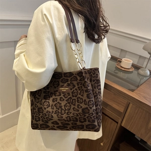Sac fourre-tout léopard vintage avec chaîne dorée porté par un mannequin dans un décor cozy