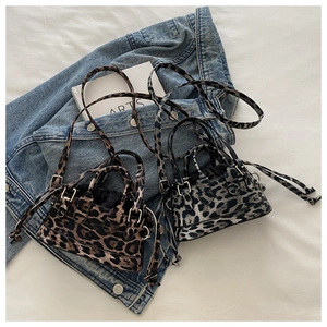Detail view of mini leopard print crossbody bags in brown and grey-blue faux leather