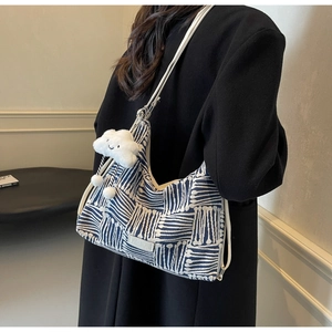 Blue and white wave pattern canvas tote bag with a white fluffy cloud charm on shoulder
