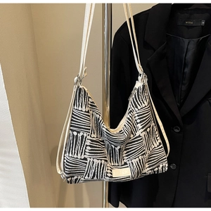 Detail view of large striped canvas tote bag with woven geometric pattern and white straps