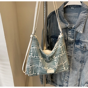 Detail of green and white striped canvas tote bag with fashion tag on metal stand