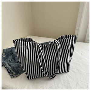 Détail d'un grand sac cabas en toile rayée montrant la texture épaisse et résistante