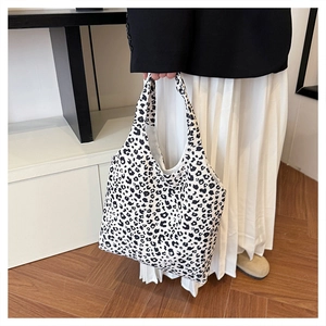Detailed view of the black and white leopard print on a canvas shoulder tote bag