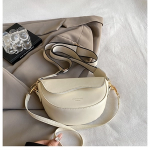 Detail of beige saddle bag with wavy flap design and dual stylish shoulder straps
